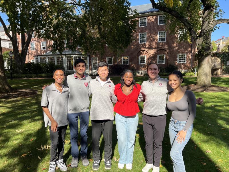 6 people standing in the courtyard of Harvard's Admissions Office building.