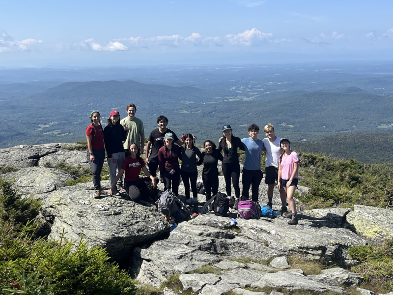 Students posing for a picture on top of a rocky area