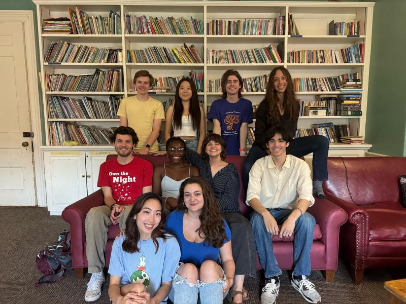 A group of students posing for a photo in front of a bookshelf