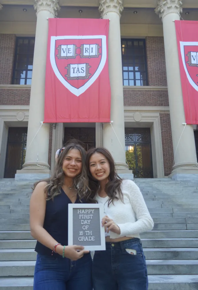 This is a picture of Ana and her friend Laura in front of Widener Library, holding up a sig that reads " Happy first day of 16th grade". They both look very happy together.