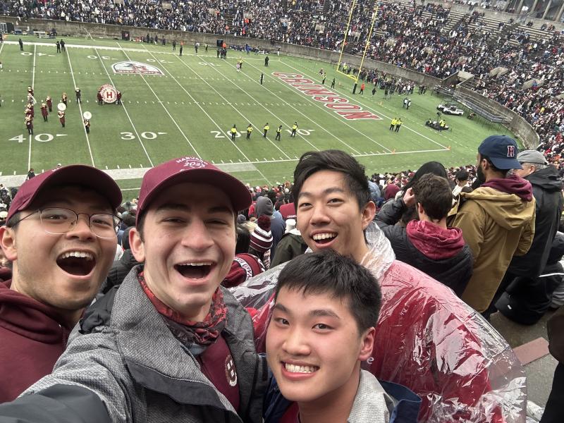 Selfie picture of Raymond and his friends at the Harvard-Yale football game with the field in the background.