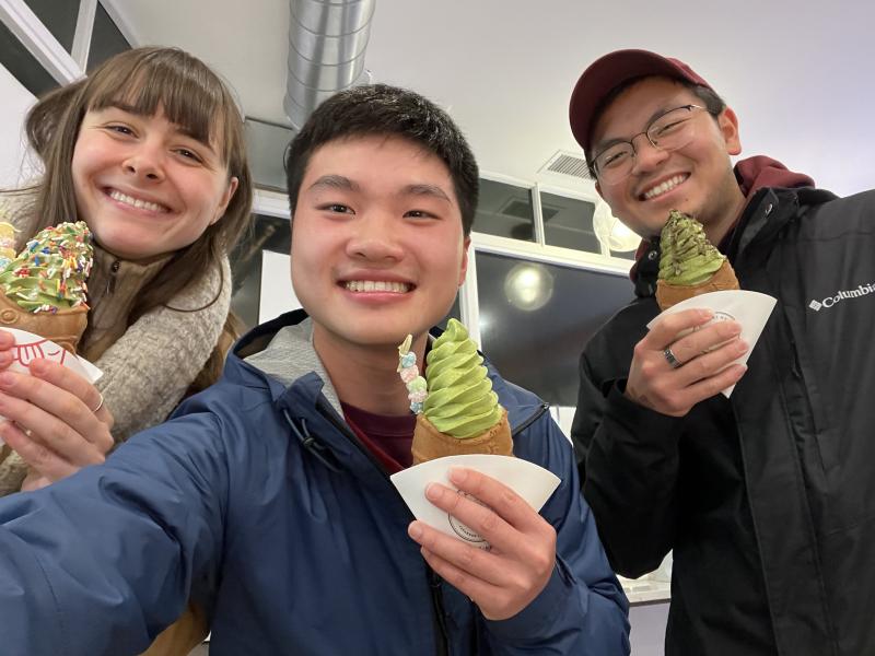 Picture of Raymond and his friends smiling at the camera holding an ice cream on a fish cone from Taiyaki.