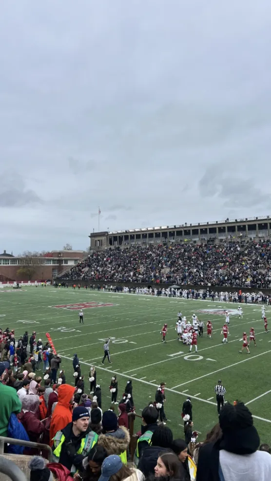 Football stadium filled with Harvard and Yale fans rooting for their team. 