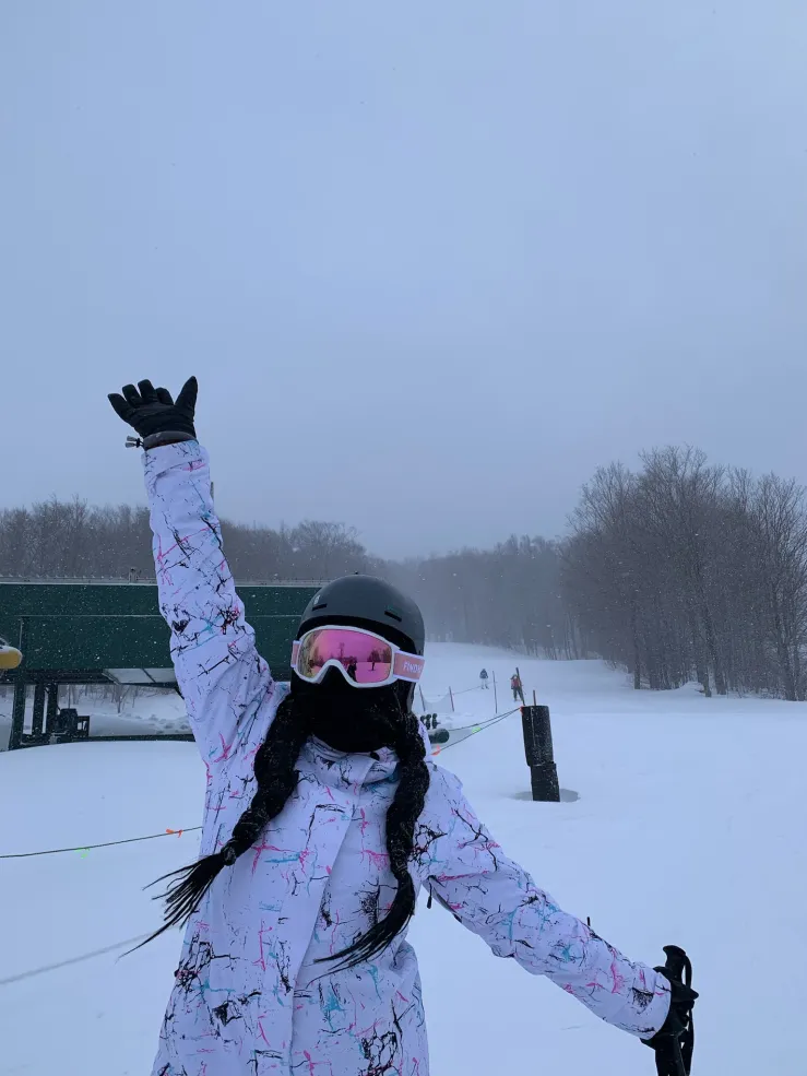 Student posing in ski gear standing on the mountain