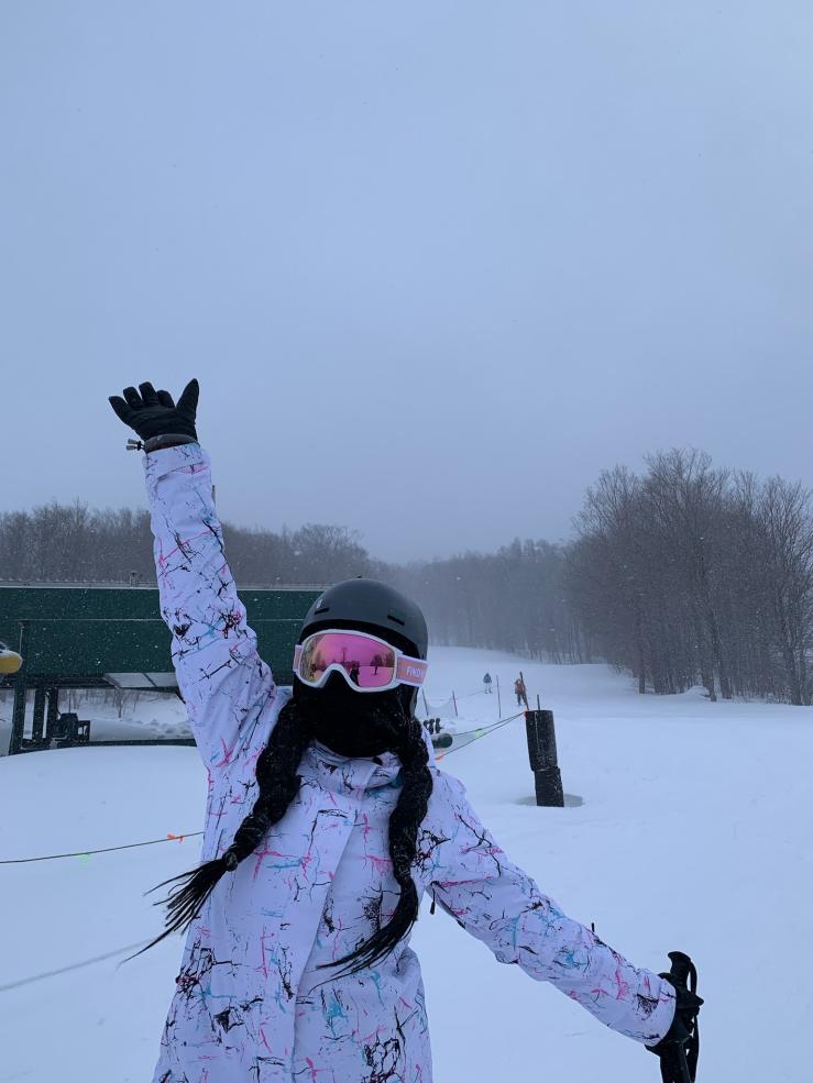 Student posing in ski gear standing on the mountain
