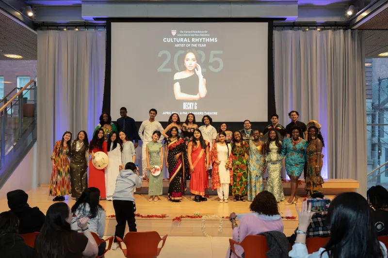 This is a picture of a group of students at the fashion show posing for a picture with their cultural clothes on