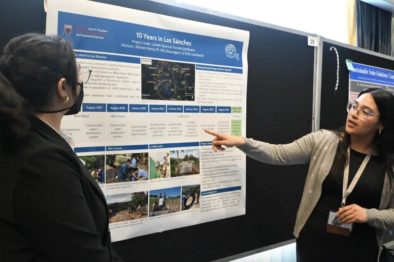 Lizbeth and Victoria presenting 10 Years in Los Sánchez during the poster showcase. 