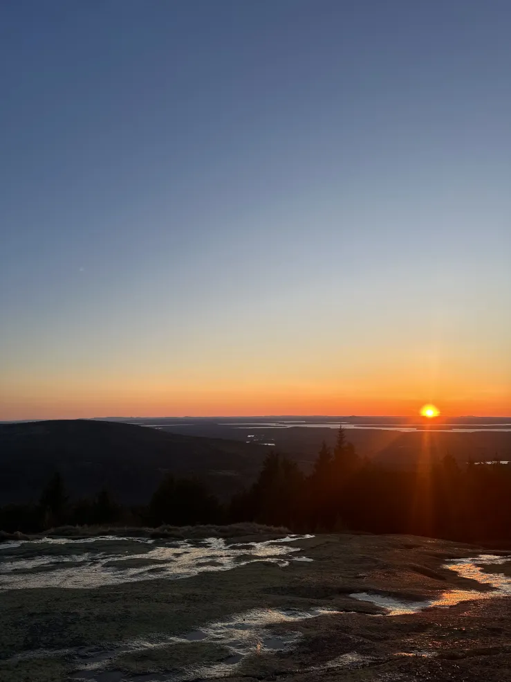 A warm-colored sunset from a high view in the Acadia National Park. 