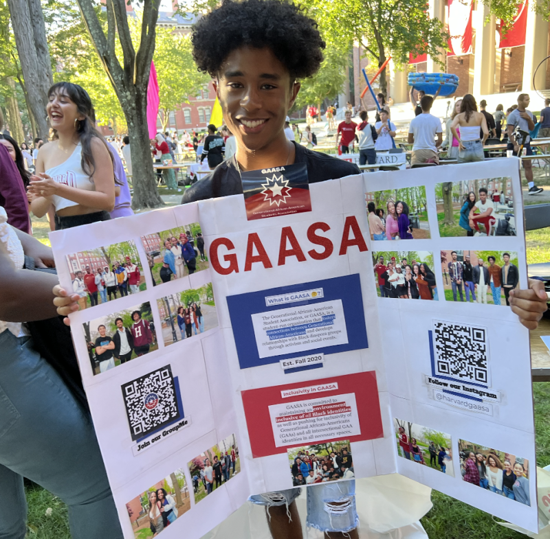 Ricardo holding up a poster board during the student activites fair