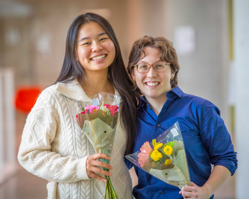 Image of Zora and Bella posing together and holding flowers