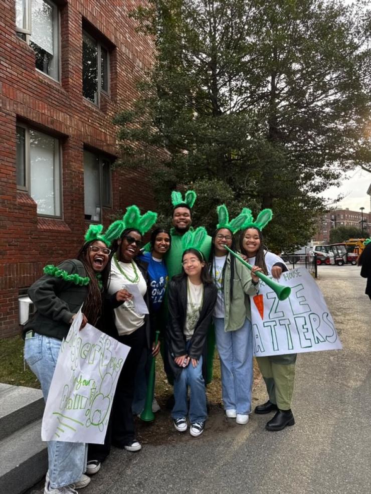 Group of students in front of Canaday Hall, a first year dorm. Most are wearing Leverett House merchandise, with one person wearing a Lowell House shirt.