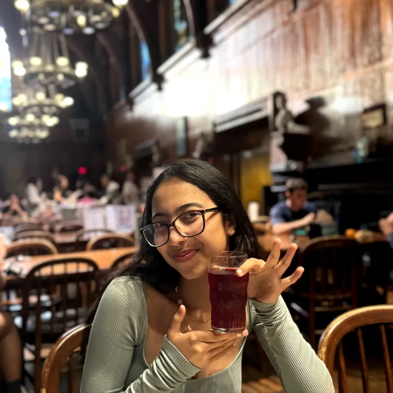 The author holding up a delicious crimson-colored (dark red) drink she created, called Crimson Calm, at Annenberg.