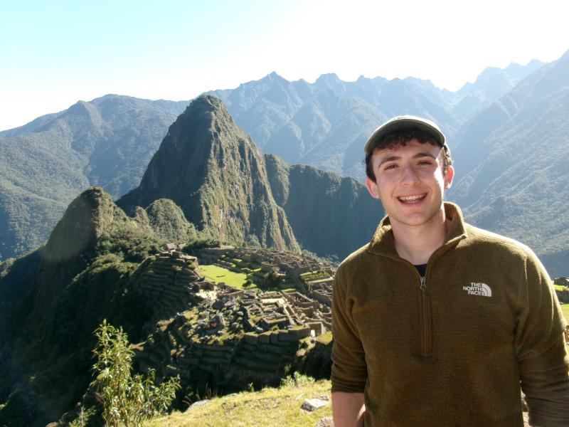 Benjamin stands along a green landscape in Chile during his summer program.