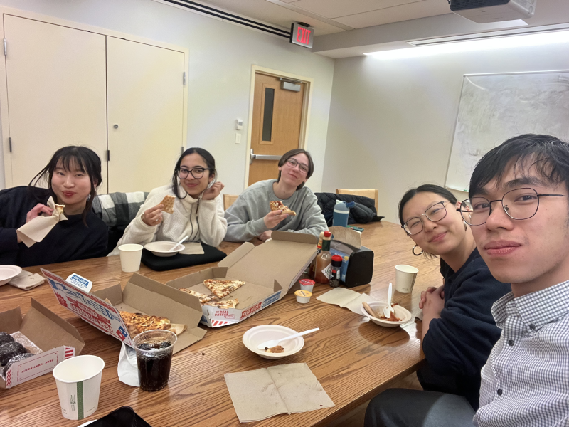 With my BachFam during a casual gathering outside of rehearsal sitting at a table, and enjoying pizza.