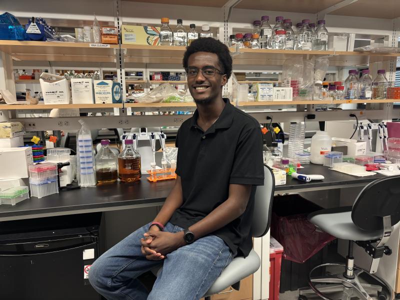Yerson smiles at his lab desk during his summer research program.