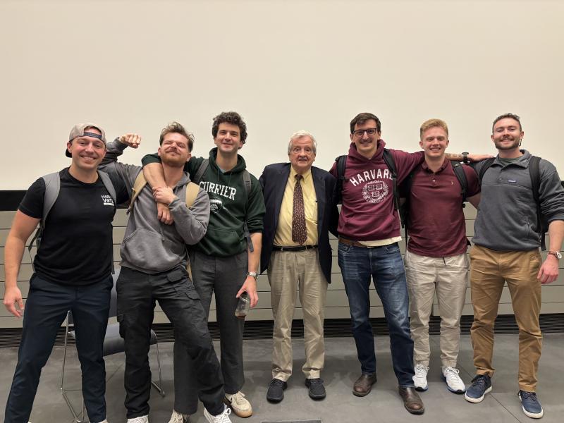 Harvard Veterans standing with Dr. Greg Nagy in the front of a lecture hall