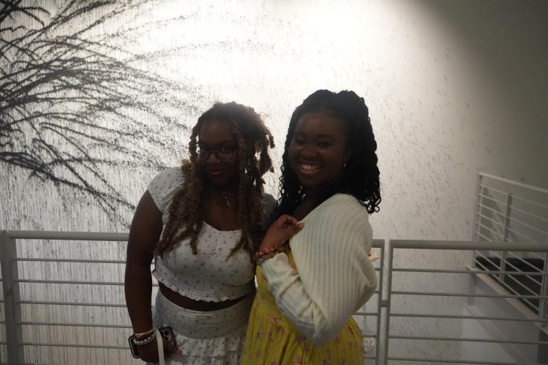 Two friends smiling and posing together inside the Art Musuem.