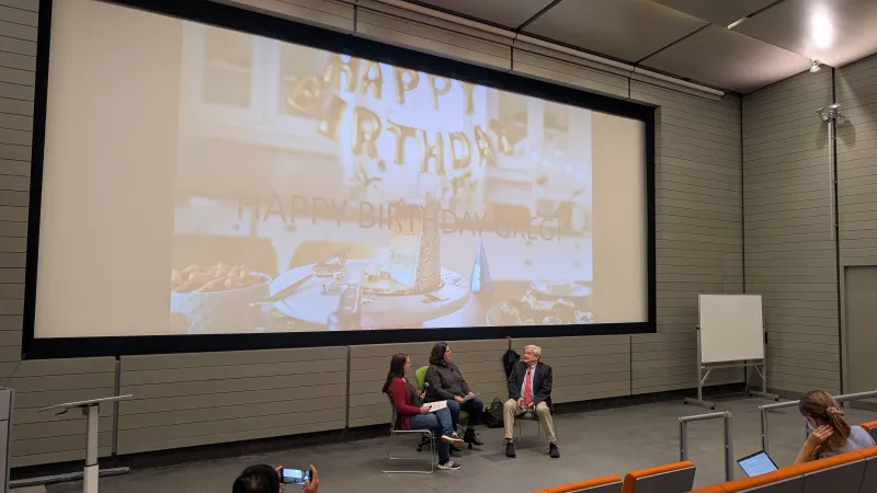 Dr. Nagy sits at the front of a lecture hall while students wish him a happy birthday.
