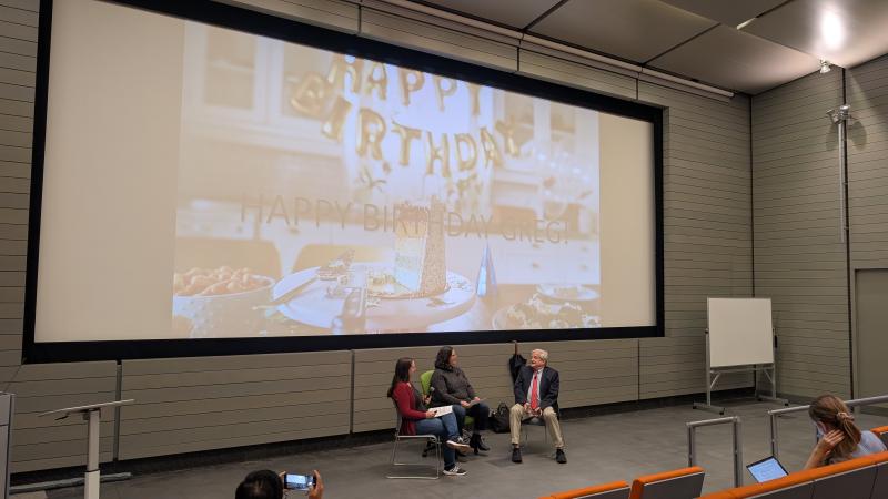 Dr. Nagy sits at the front of a lecture hall while students wish him a happy birthday.