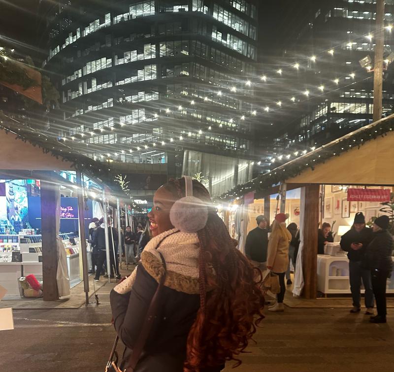 Picture of a girl posing at a festive outdoor winter market 