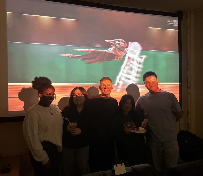 5 people standing in front of a projector screen.