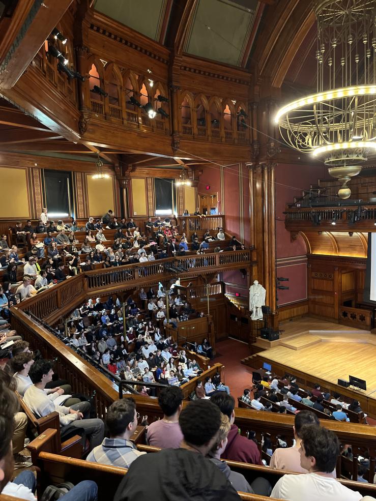 Sanders Theater full of students attending a session of Justice, taught by Michael Sandel.