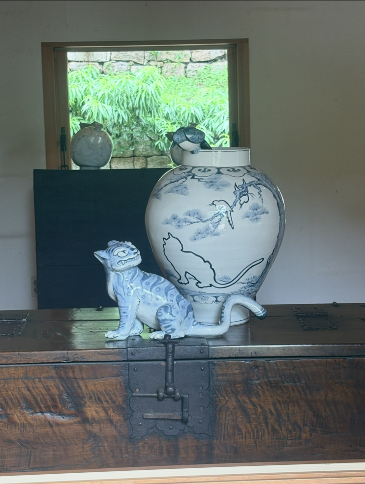 A blue and white ceramic vase with a matching bird and cat-like character