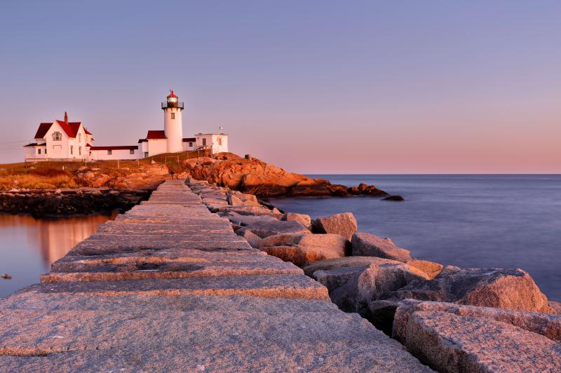 Pink sunset behind white lighthouse in Gloucestor, MA.