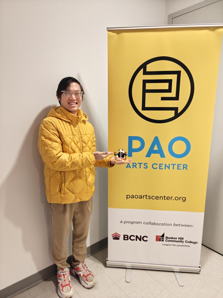 Joseph Foo '26 smiling next to the PAO Arts Center sign.