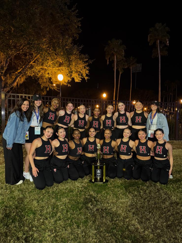 The Dance Team outside after the competition posing with their trophy and coaches.