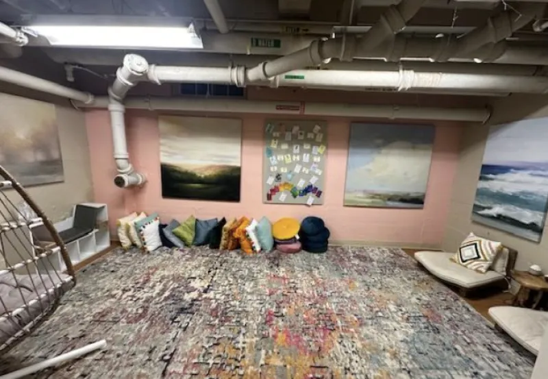 Picture of the Kirkland House meditation space with a colorful carpet and plenty of pillows.
