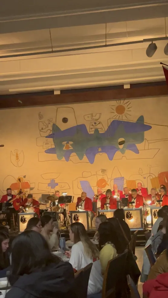 The Quincy House Dining Hall on Housing Day with soft lighting and a band playing on the stage
