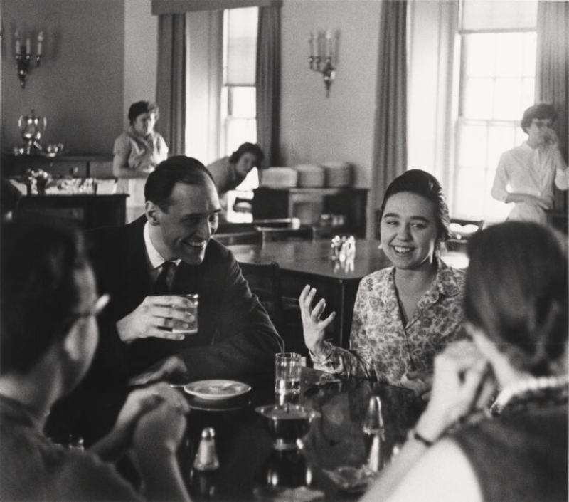 Black and white image of previous North House residents sitting at a table talking.
