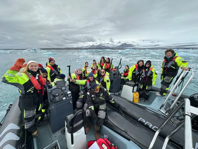 Students on a boat in Iceland surrounded by icebergs.
