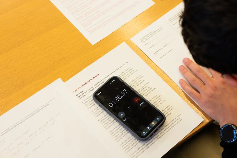 Iphone timer placed on top of paper. Paper contains details of ethics case. 