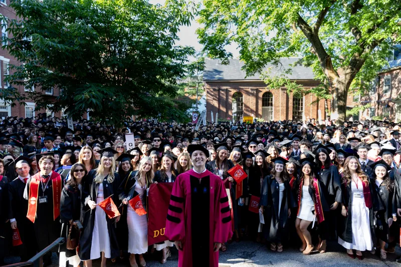 Dean David Deming standing in front of the Class of 2026 smiling at Valediction.