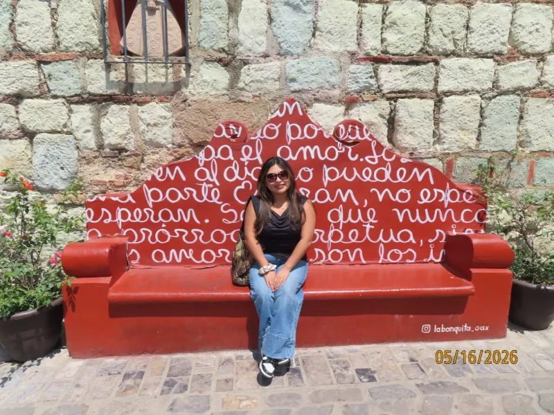 Daisy sitting on the iconic red bench in Xochimilco which features song/poem lyrics. 