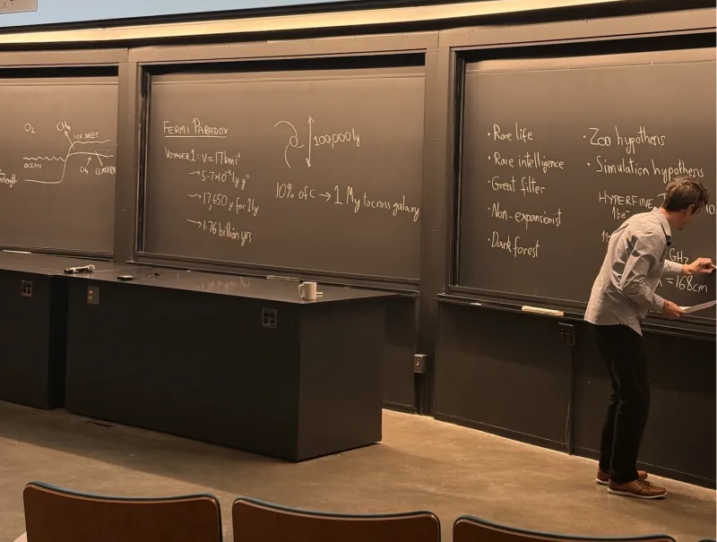 Photo of professor writing on chalk board