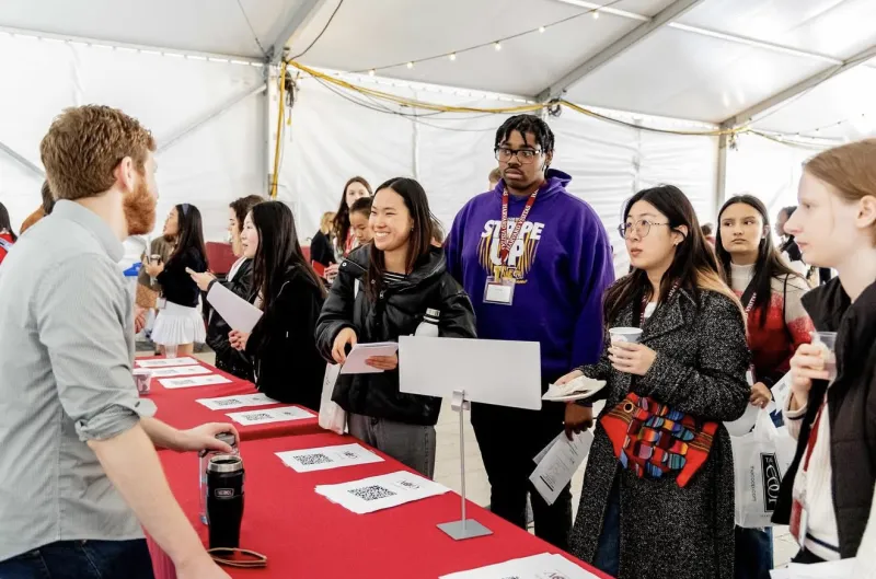 Visitas Concentration Fair 2024. Students lined up at table listening to a concentration advisor.