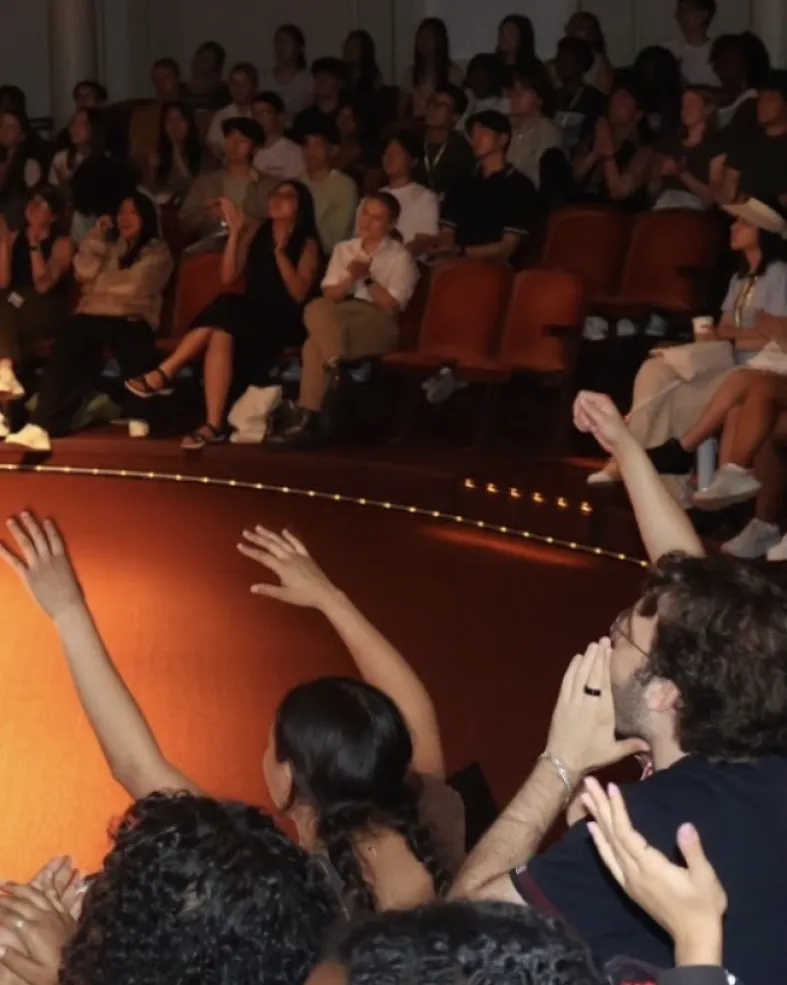 A diverse group of students cheering for their presenters