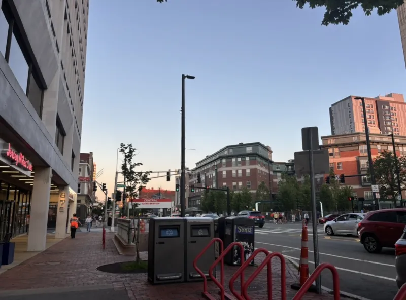 Multiple buildings at a traffic intersection and the sunset in the background
