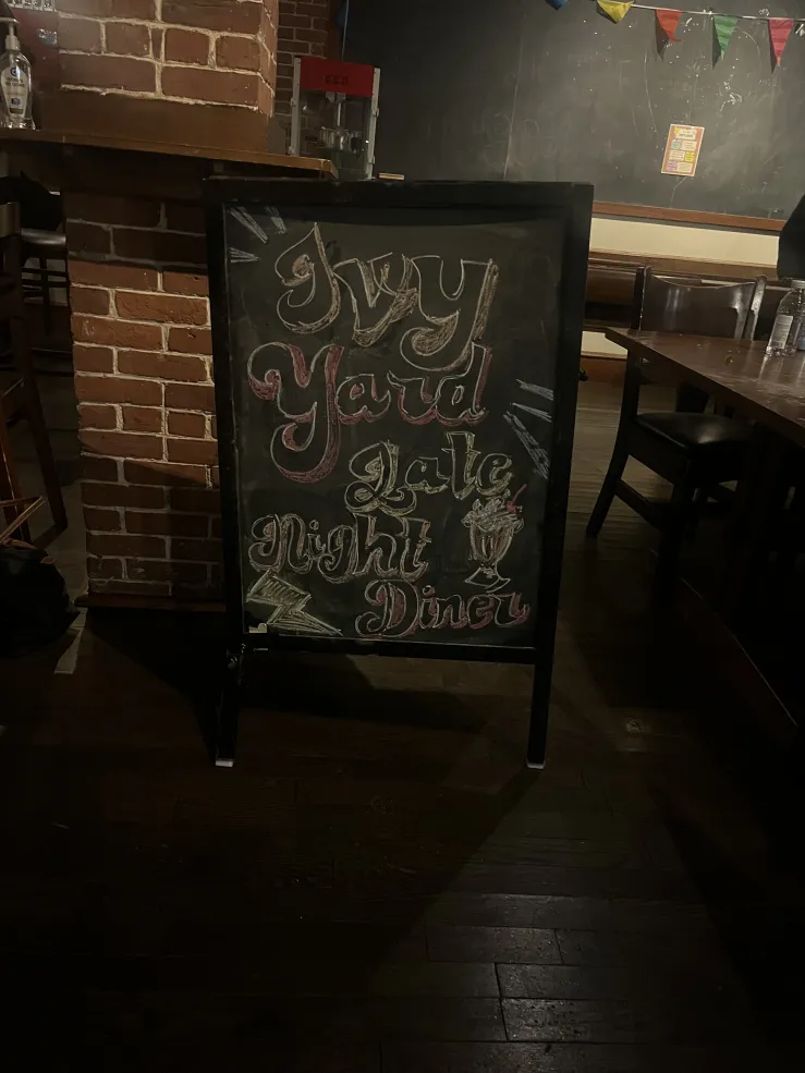A black chalkboard with colorful words reading, "Ivy Yard Study Break Late Night Diner"