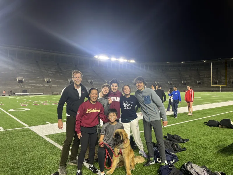 Kirkland House's resident dean family and student-athletes pose for a group photo on the football field.