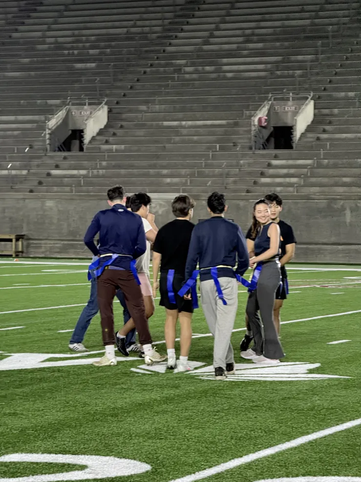 Kirkland athletes huddle together on the football field preparing their next play.