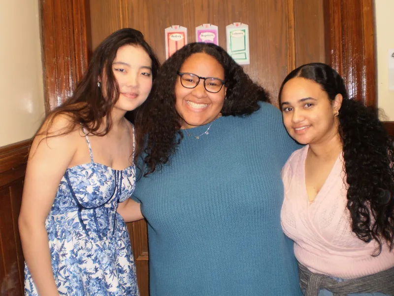 Three roommates outside of their room dorm. 