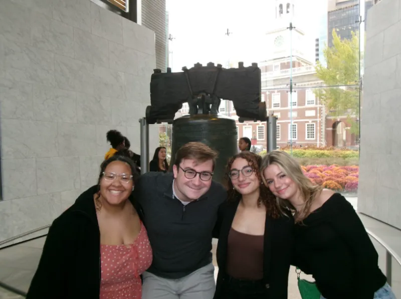 Four teammates in front of the liberty bell.