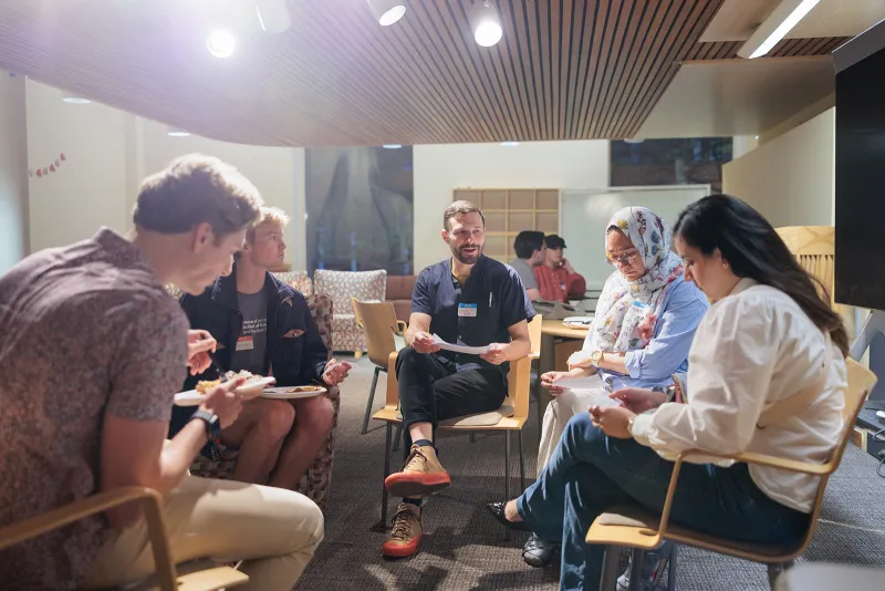 A small group of students sits in a circle talking