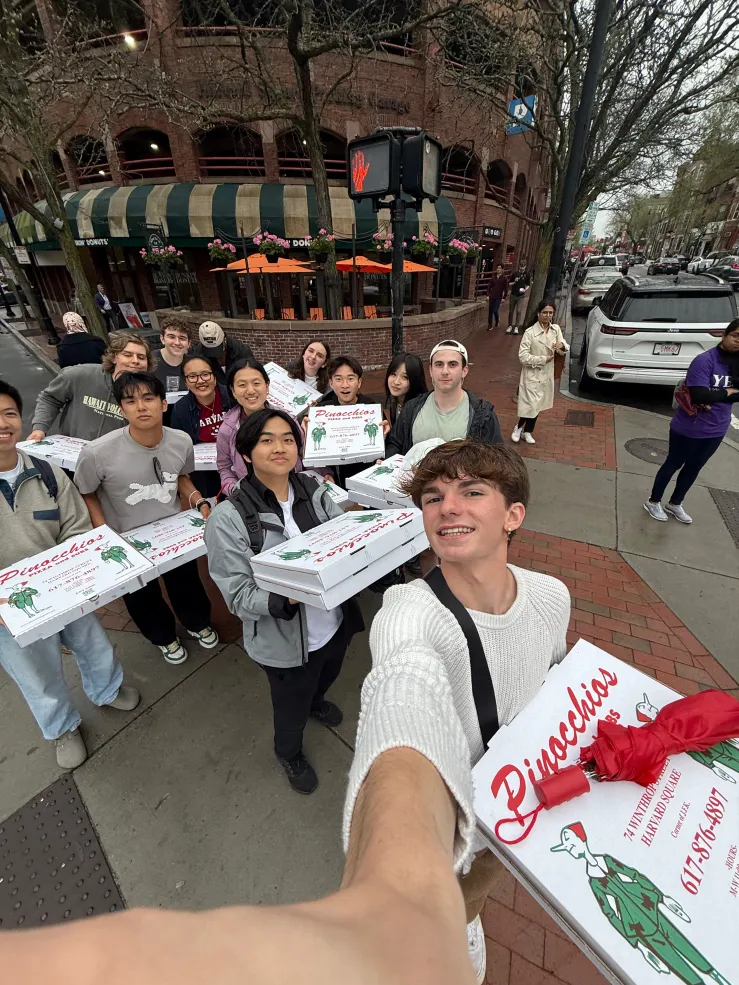 Selfie photo of Harvard admitted students carrying Pinocchio's Pizza