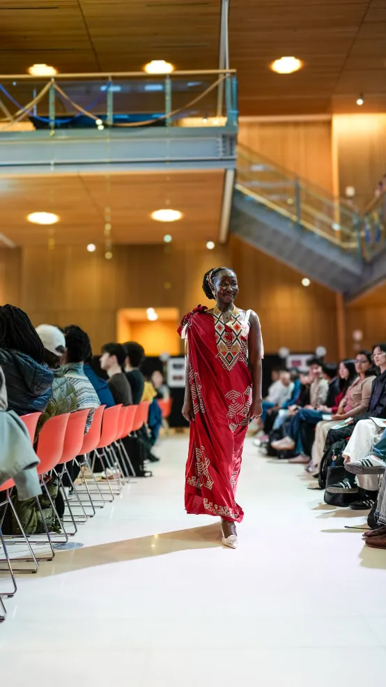 During Cultural Rhythms Week, I walked the runway wearing a traditional South Sudanese outfit. I am dressed in a vibrant red Lawa, a traditional garment, paired with handcrafted South Sudanese beadwork, including layered neck beads and a matching beaded headband. Together, these pieces celebrate the artistry and cultural heritage of South Sudan, allowing me to represent my country through fashion.