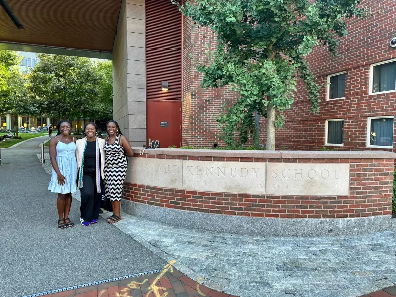 My sister and I with our aunt next to the Harvard Kennedy School sign